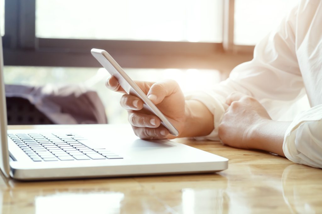 Person Using Phone And Computer